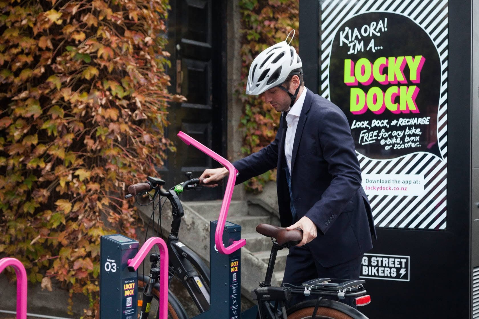 A commuter in business attire locking an e-bike into a Locky Dock secure bike parking station