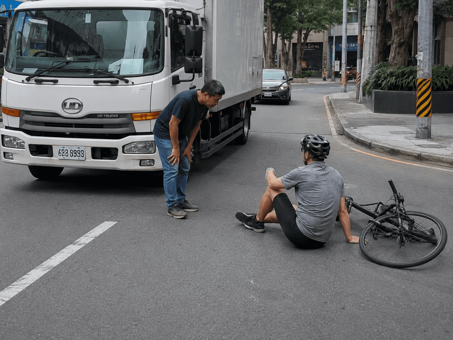 Illustrative stock photo of a truck and a fallen cyclist following a road incident, used to represent the topic of this article